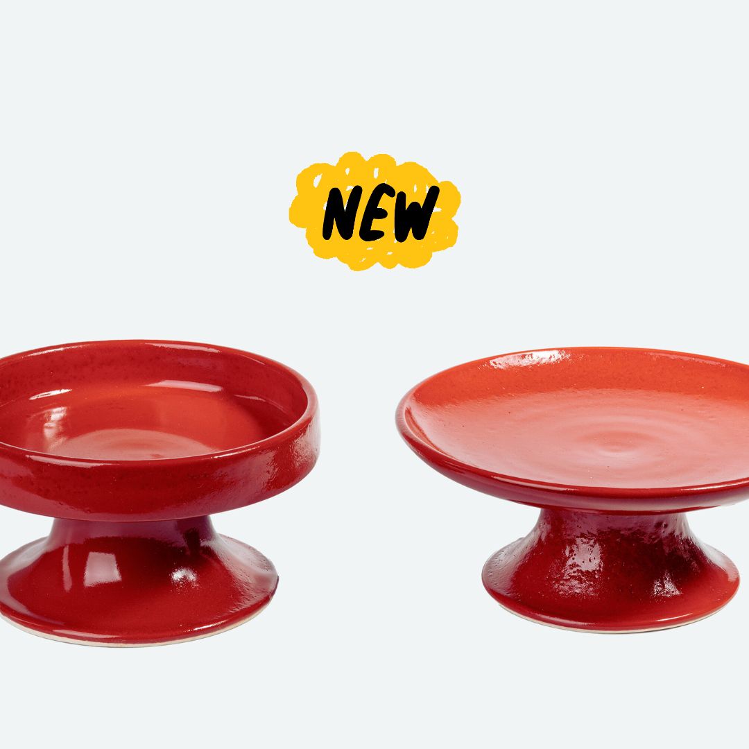 Set de comederos elevados de cerámica rojo para gatos, con diseño ergonómico y estilo vibrante.