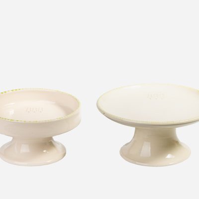 Set de comederos elevados de cerámica beige para gatos, con detalles verdes y diseño ergonómico.