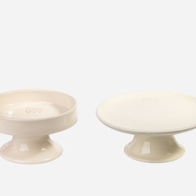 Set de comederos y bebederos elevados de cerámica beige para gatos, con diseño minimalista y ergonómico.